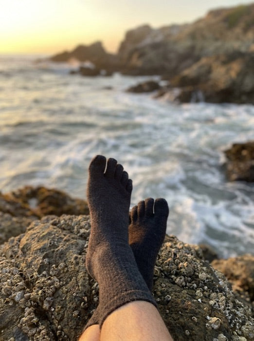 Toe socks resting on rocks by the sea
