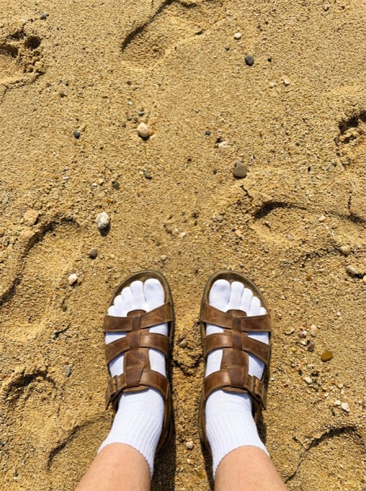 Toe socks worn with sandals on the beach
